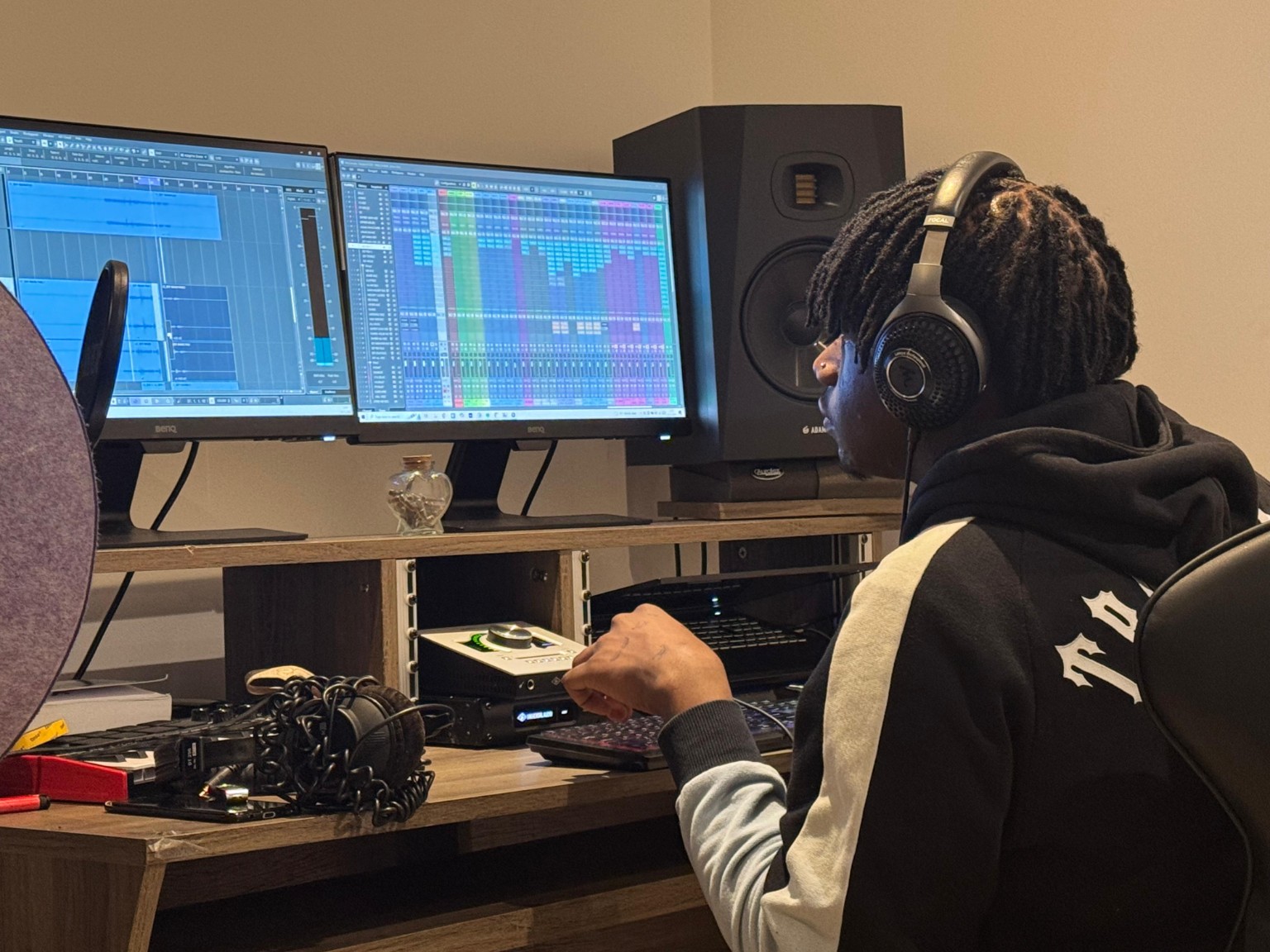 Donx wearing headphones while working on a mix at the studio desk.